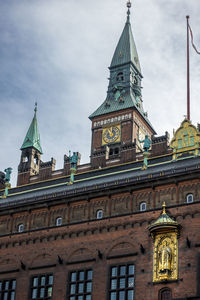 Low angle view of copenhagen city hall clock tower against sky