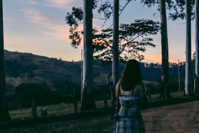 Silhouette of woman standing by tree