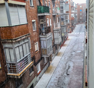 High angle view of wet street amidst buildings in city