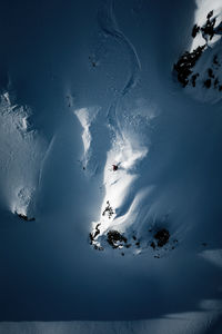 Aerial view of people skiing on snowcapped mountain