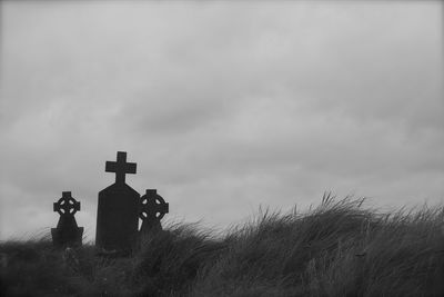 View of field against cloudy sky