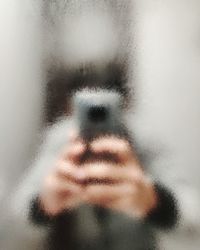 Close-up of blurred human hand holding a smartphone