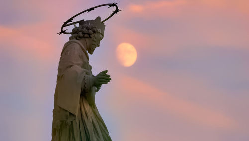 Low angle view of statue against sky during sunset