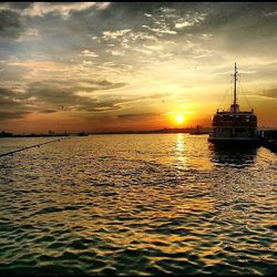 Scenic view of sea against cloudy sky during sunset