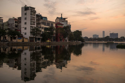 Reflection of buildings in lake at sunset