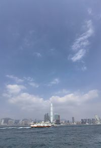 Sea by buildings against sky in city