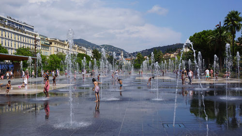 People at swimming pool against sky