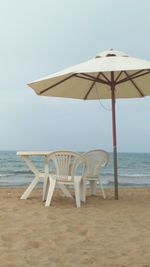 Deck chairs on beach against clear sky