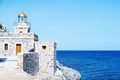 Lighthouse at monemvasia in sea against clear sky