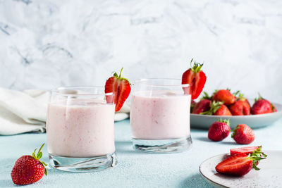 Milk smoothie with strawberries and mint in glasses on the table. healthy homemade food
