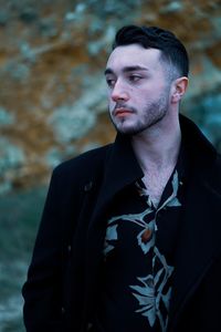 Portrait of young man looking away outdoors