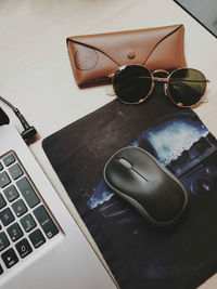 High angle view of sunglasses and laptop on table