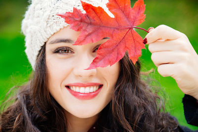 Close-up portrait of a young woman with autumn leaves