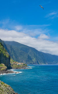 Scenic view of sea and mountains against sky