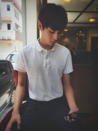 Young man using mobile phone in restaurant