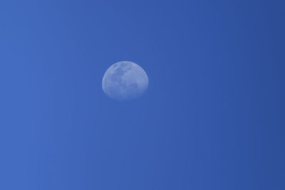 Low angle view of moon against blue sky