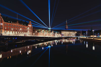 Illuminated bridge over river at night