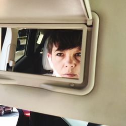 Reflection of woman in car on mirror