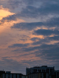 Buildings against cloudy sky during sunset