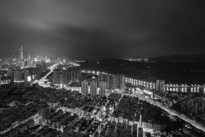 High angle view of illuminated buildings against sky at night