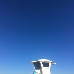 Low angle view of cross against clear blue sky