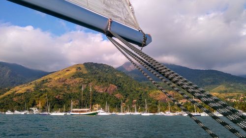 Scenic view of sea by mountains against sky