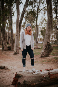 Full length portrait of young woman in forest