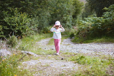 Full length of young girl  walking  on  countryside road