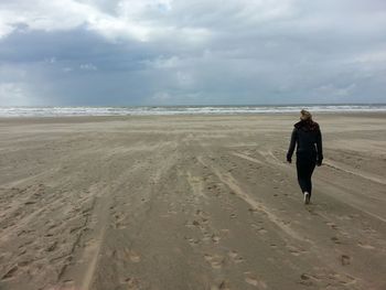 Scenic view of beach against cloudy sky
