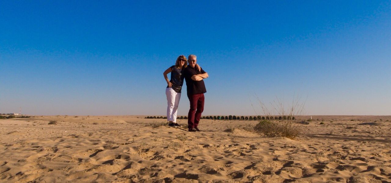 WOMAN WALKING ON SANDY BEACH