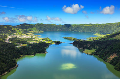 Scenic view of lake and mountains against blue sky