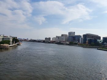 River amidst buildings in city against sky