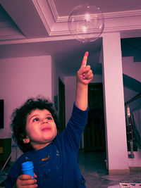 Portrait of cute boy standing against wall