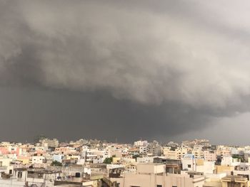 View of residential district against storm clouds