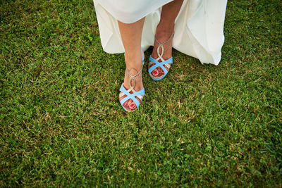 Low section of bride standing on field