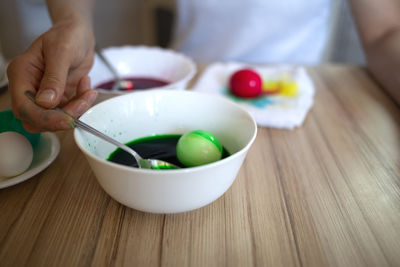 Midsection of man holding bowl on table