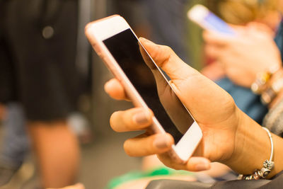 Cropped hand of people using smart phones outdoors