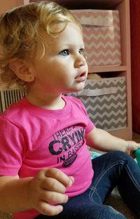 Close-up of cute baby girl sitting at home