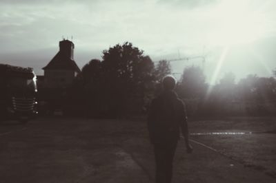 Rear view of silhouette man against building