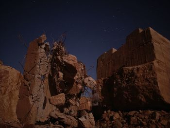 Low angle view of rock formation against sky at night