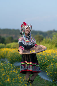 Woman with umbrella standing on field