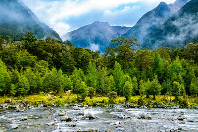 Scenic view of river amidst mountains against sky