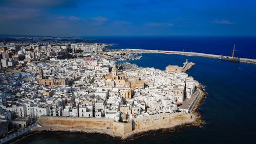 High angle view of city by sea against sky