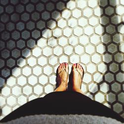 Low section of woman standing on tiled floor