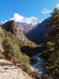 High angle view of man hiking on cliff against mountain and canal