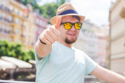 Portrait of young man wearing sunglasses standing outdoors