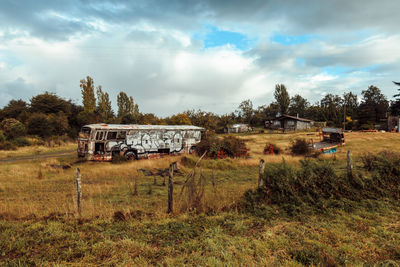 Abandoned vehicle on field against sky