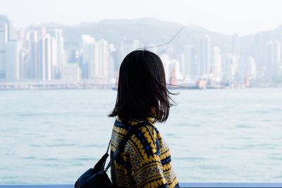 Woman standing by river in city