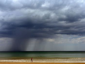 Scenic view of sea against storm clouds