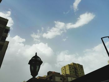 Low angle view of buildings against cloudy sky